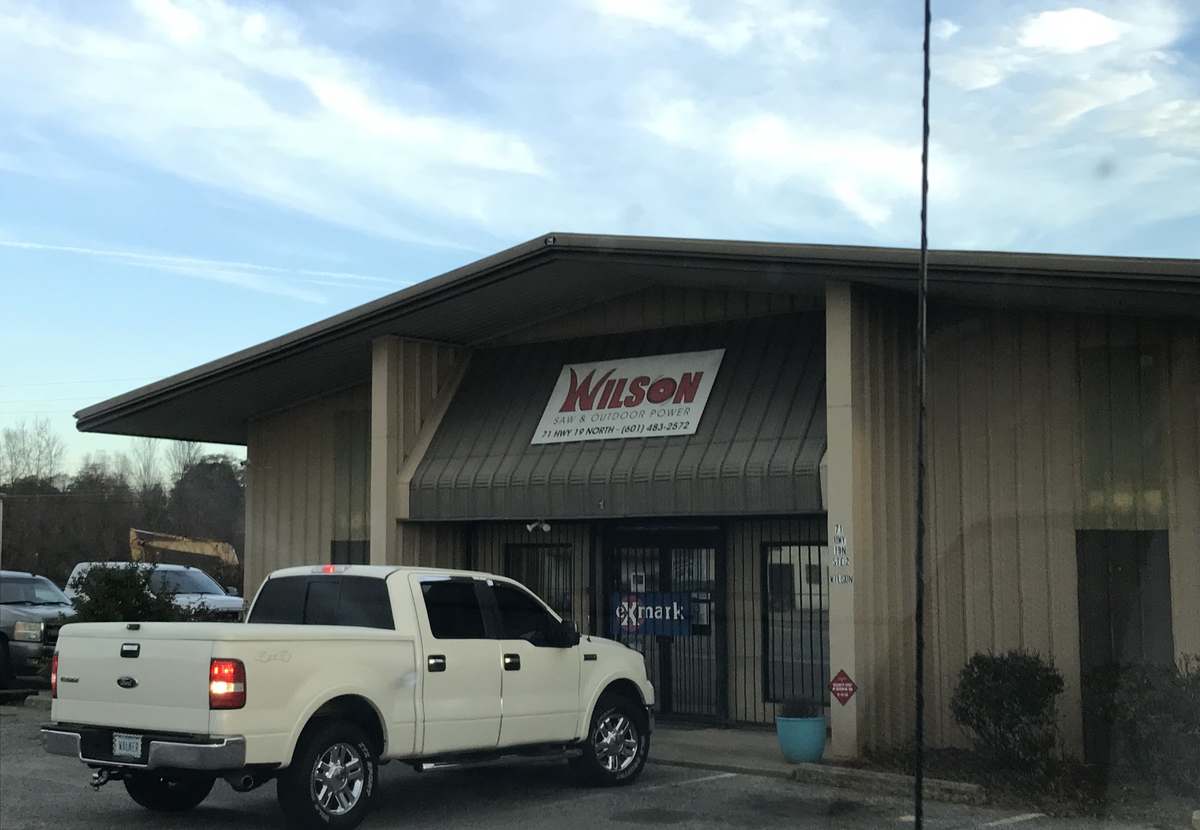 Wilson Saw & Outdoor Power branded storefront with the eXmark dealer sign at the door